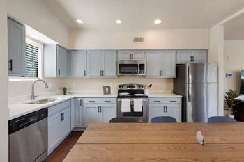 A kitchen with a wooden table in front of it.